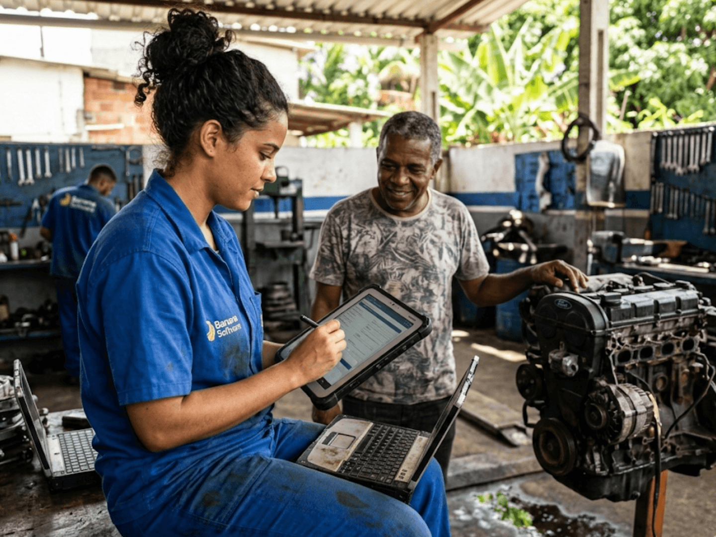 Técnica registrando ordem de serviço no tablet junto ao cliente na oficina mecânica